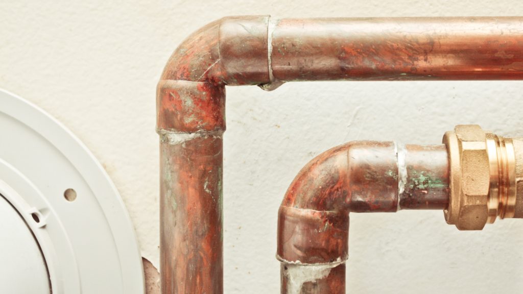 two old rusted pipes with a leak