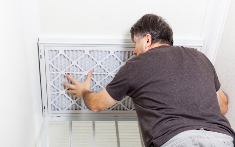 a man replacing the air filter for hvac