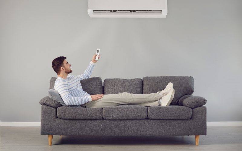 man lying on couch with ac working
