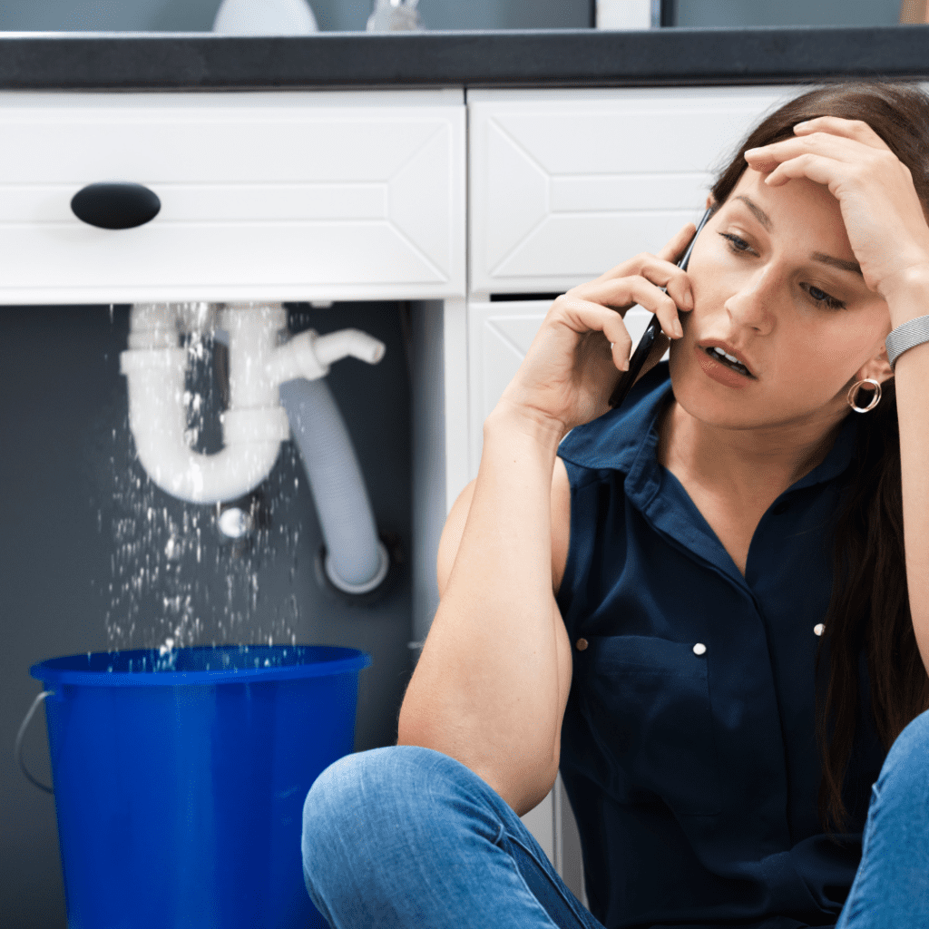 woman on the phone with a water leak behind her